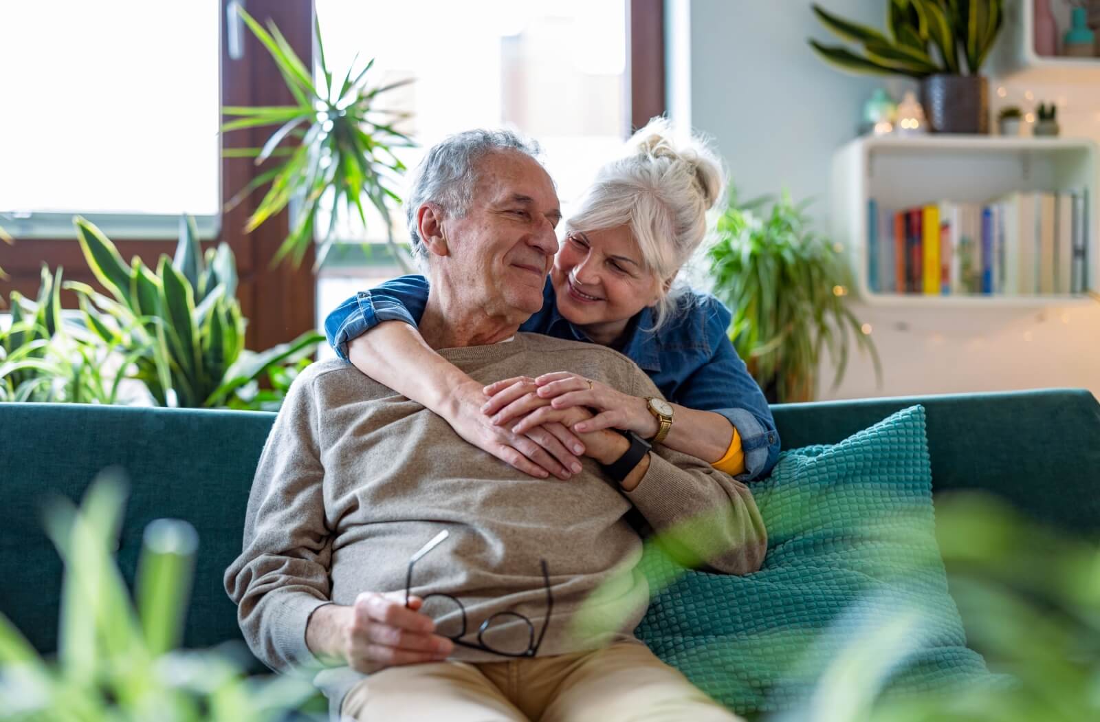A mature couple happily embracing one another in their independent living suite.