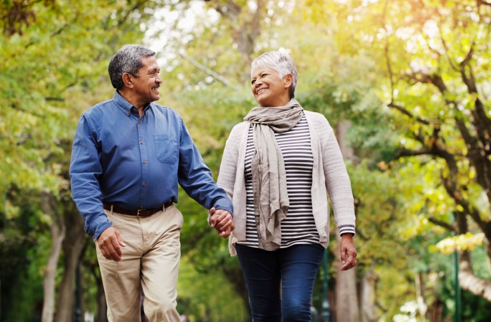 A happy senior couple enjoying a walk outdoors together.